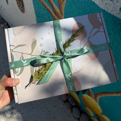 A sympathy gift box beautifully wrapped with sage green ribbon and a sprig of rosemary 